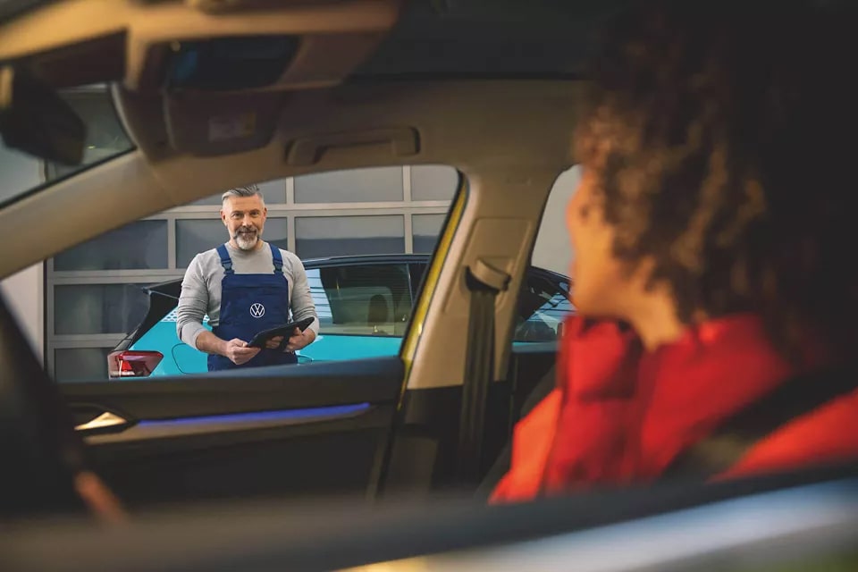 femme dans une voiture arrivant au garage pour son entretien mécanique